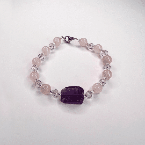 Pulsera de cuarzo rosado y piedra amatista central.